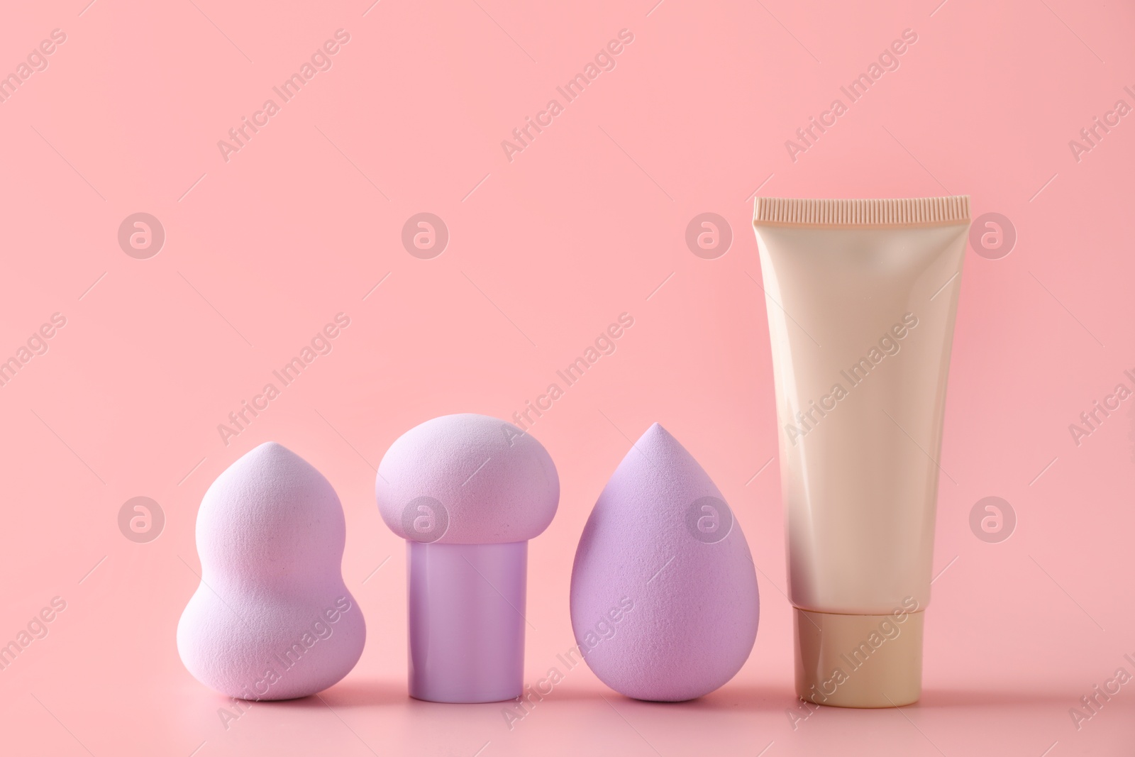 Photo of Makeup sponges and skin foundation on pink background