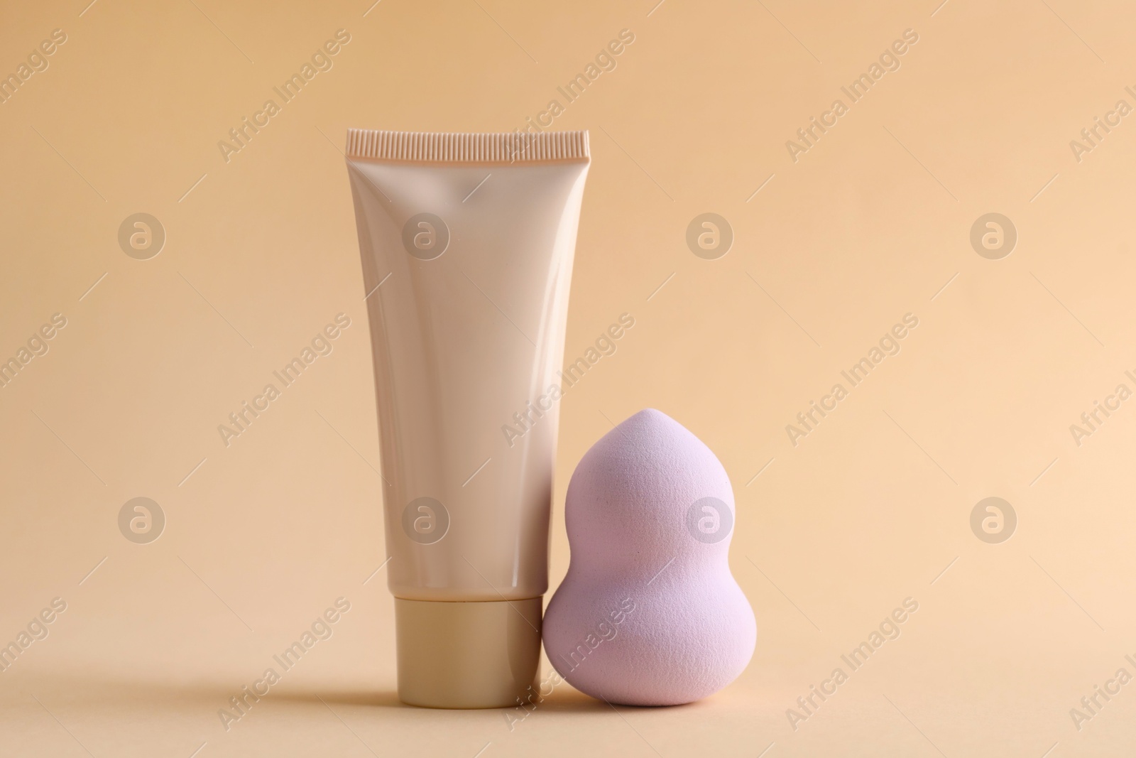 Photo of Makeup sponge and skin foundation on beige background