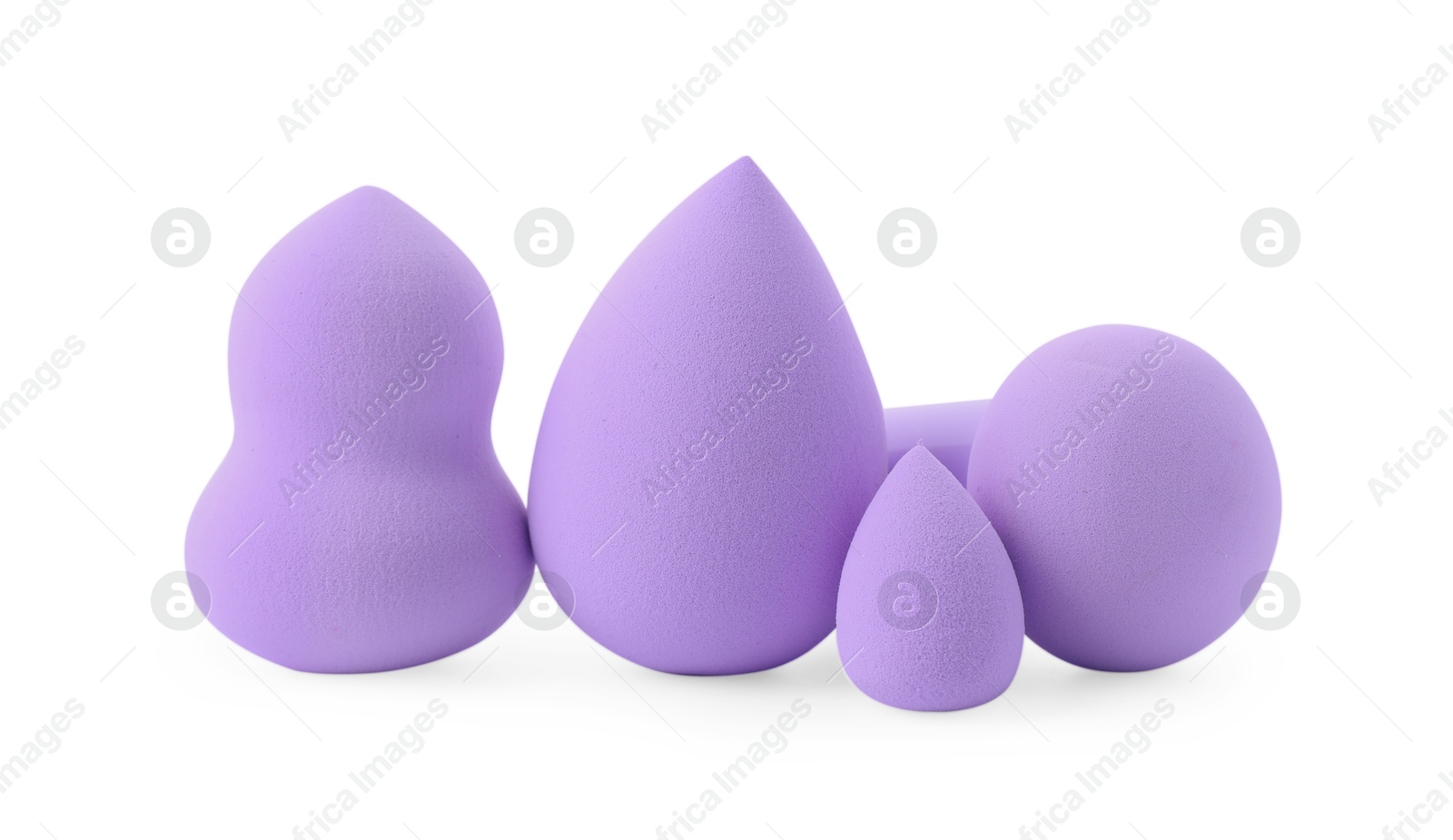 Photo of Many violet makeup sponges isolated on white