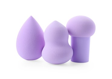 Photo of Three violet makeup sponges isolated on white