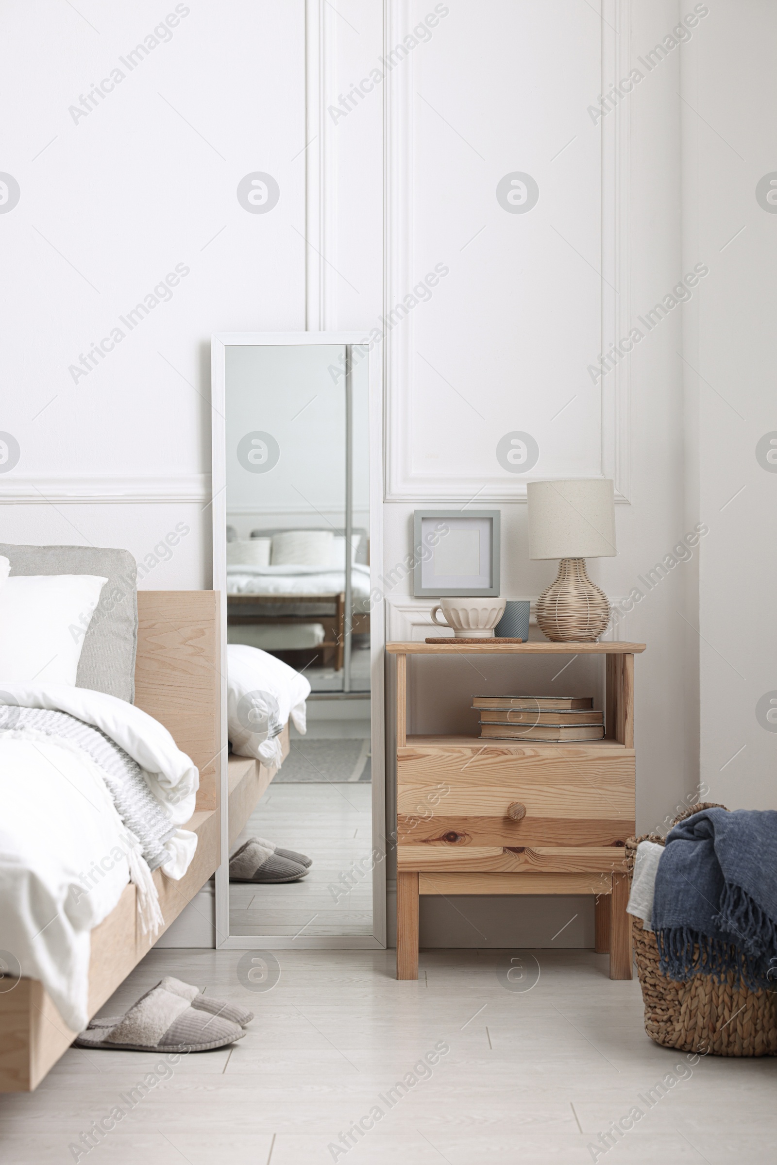 Photo of Stylish living room interior with bed, bedside table and lamp