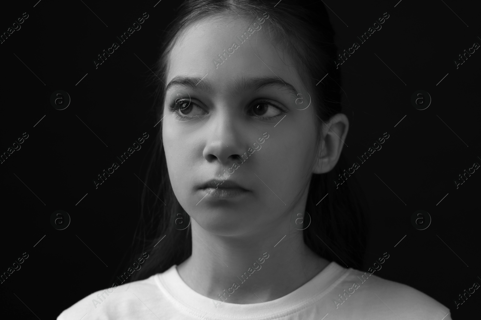 Photo of Portrait of sad girl in darkness, closeup. Black and white effect