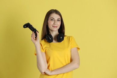 Photo of Happy woman with controller on yellow background