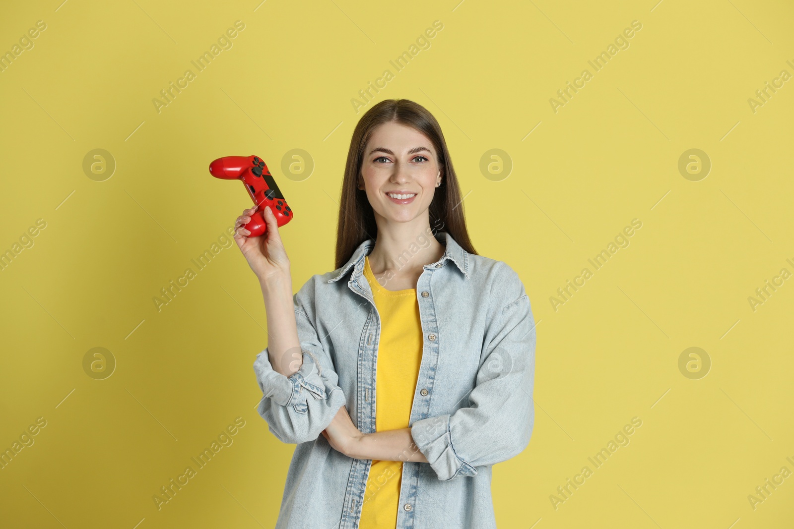 Photo of Happy woman with controller on yellow background