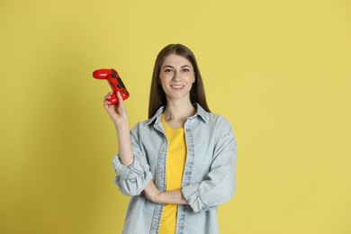 Photo of Happy woman with controller on yellow background