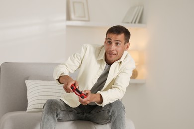 Man playing video games with joystick at home