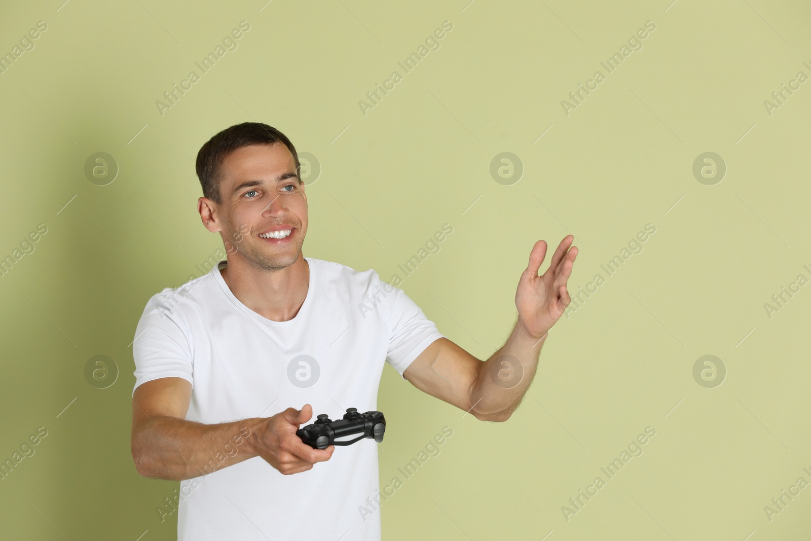 Photo of Happy man with controller on light green background, space for text