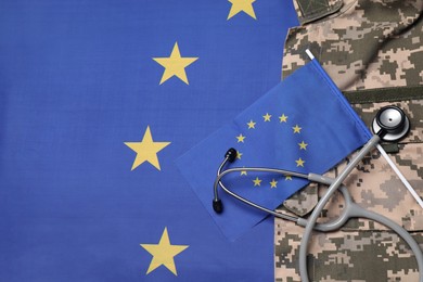 Photo of Stethoscope and military uniform on flag of European Union, top view