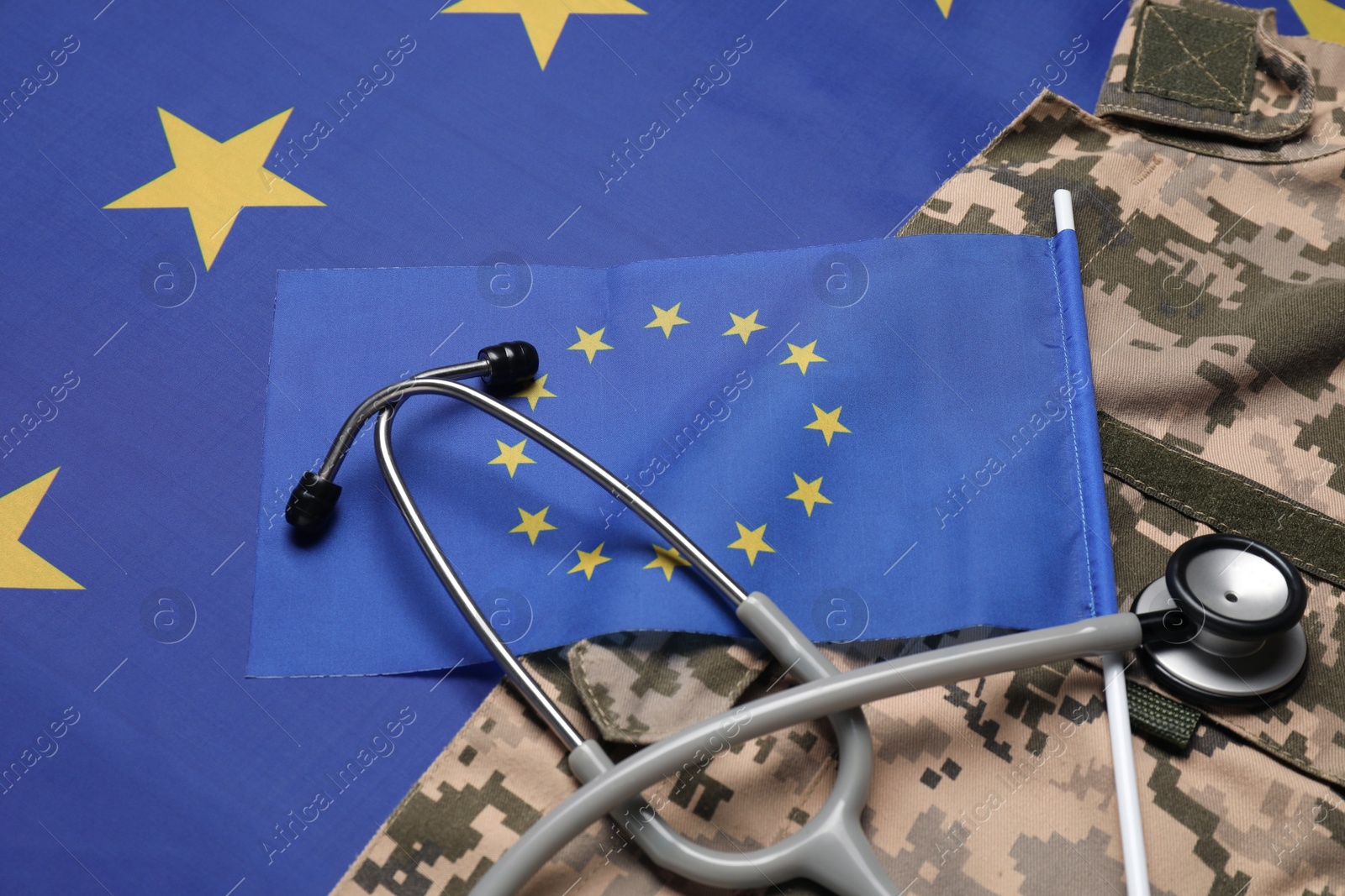 Photo of Stethoscope and military uniform on flag of European Union, closeup