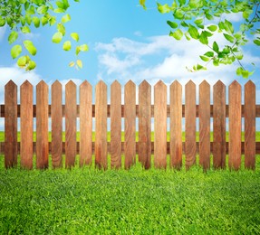 Image of Wooden fence, trees and green grass outdoors