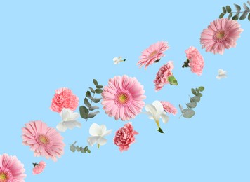 Pink gerberas and other beautiful flowers flying on light blue background