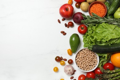 Photo of Source of protein for vegetarians. Different fresh vegetables, fruits and herbs on white marble table, space for text