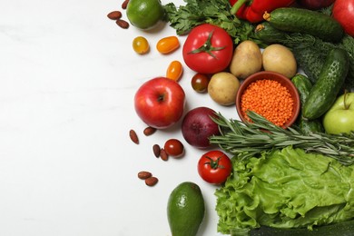 Source of protein for vegetarians. Different fresh vegetables, fruits and herbs on white marble table, space for text