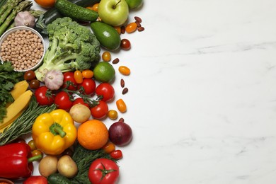 Source of protein for vegetarians. Different fresh vegetables, fruits and herbs on white marble table, space for text