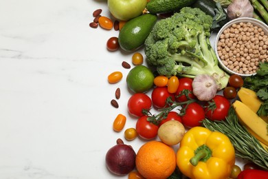 Source of protein for vegetarians. Different fresh vegetables, fruits and herbs on white marble table, space for text