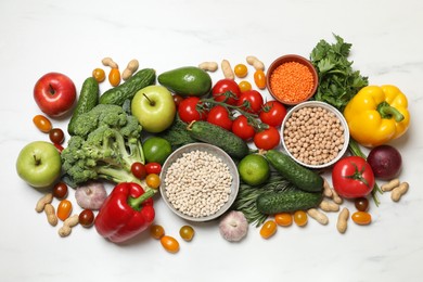 Photo of Source of protein for vegetarians. Different fresh vegetables, fruits and herbs on white marble table