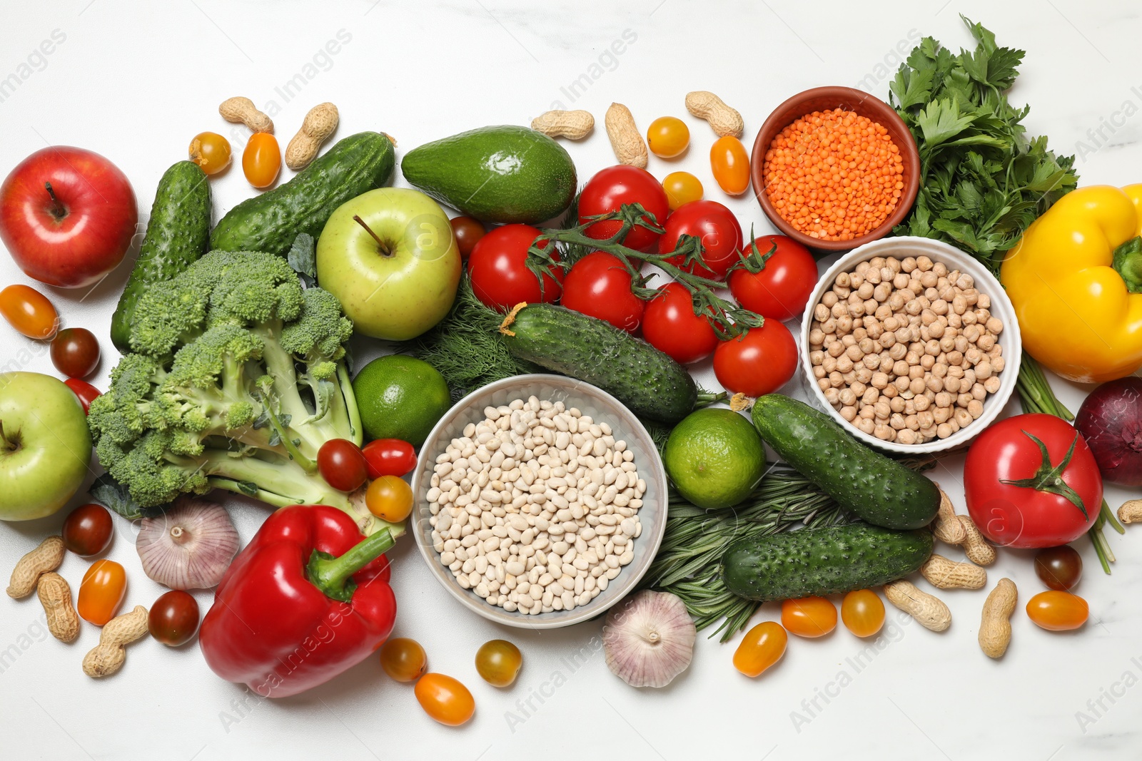 Photo of Source of protein for vegetarians. Different fresh vegetables, fruits and herbs on white marble table