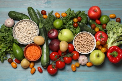 Source of protein for vegetarians. Different fresh vegetables, fruits and cereals on light blue wooden table, top view