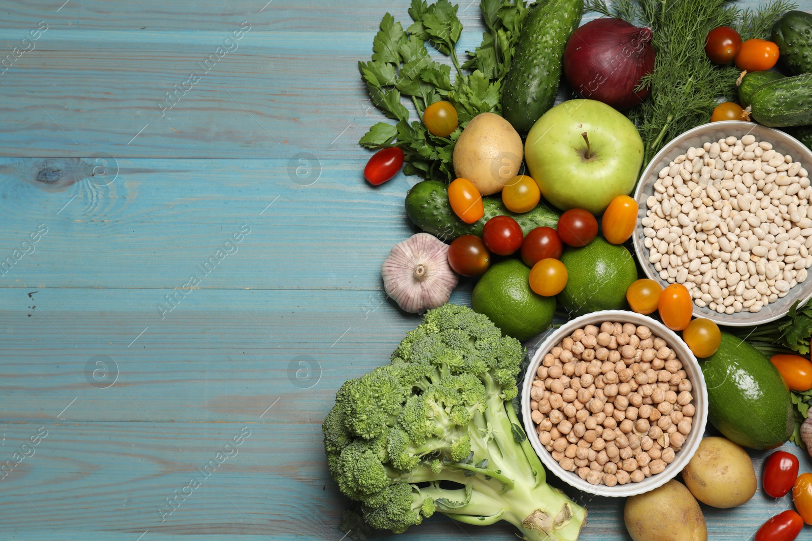 Photo of Source of protein for vegetarians. Different fresh vegetables, fruits and cereals on light blue wooden table, top view. Space for text