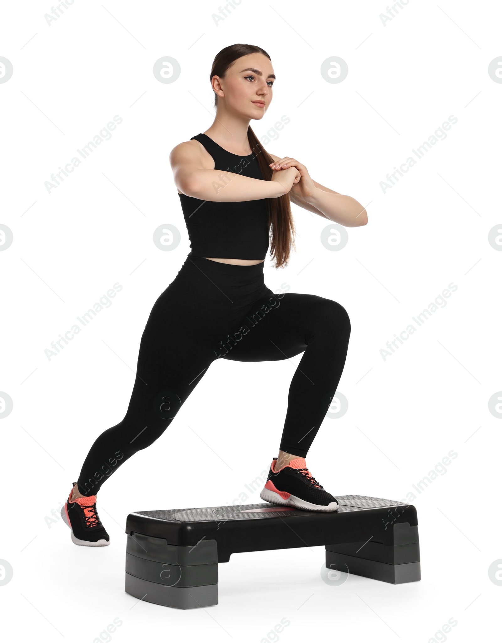 Photo of Young woman doing aerobic exercise with step platform on white background