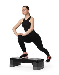 Photo of Young woman doing aerobic exercise with step platform on white background