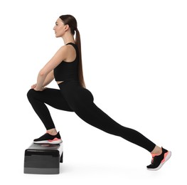 Young woman doing aerobic exercise with step platform on white background