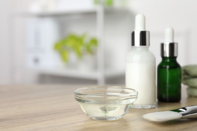 Photo of Peeling procedure. Bottles of chemical peel, bowl with liquid and brush on wooden table indoors. Space for text