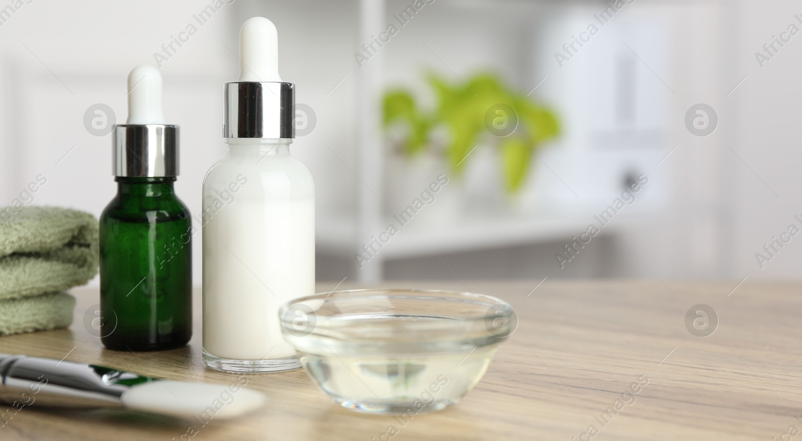 Photo of Peeling procedure. Bottles of chemical peel, bowl with liquid and brush on wooden table indoors. Space for text