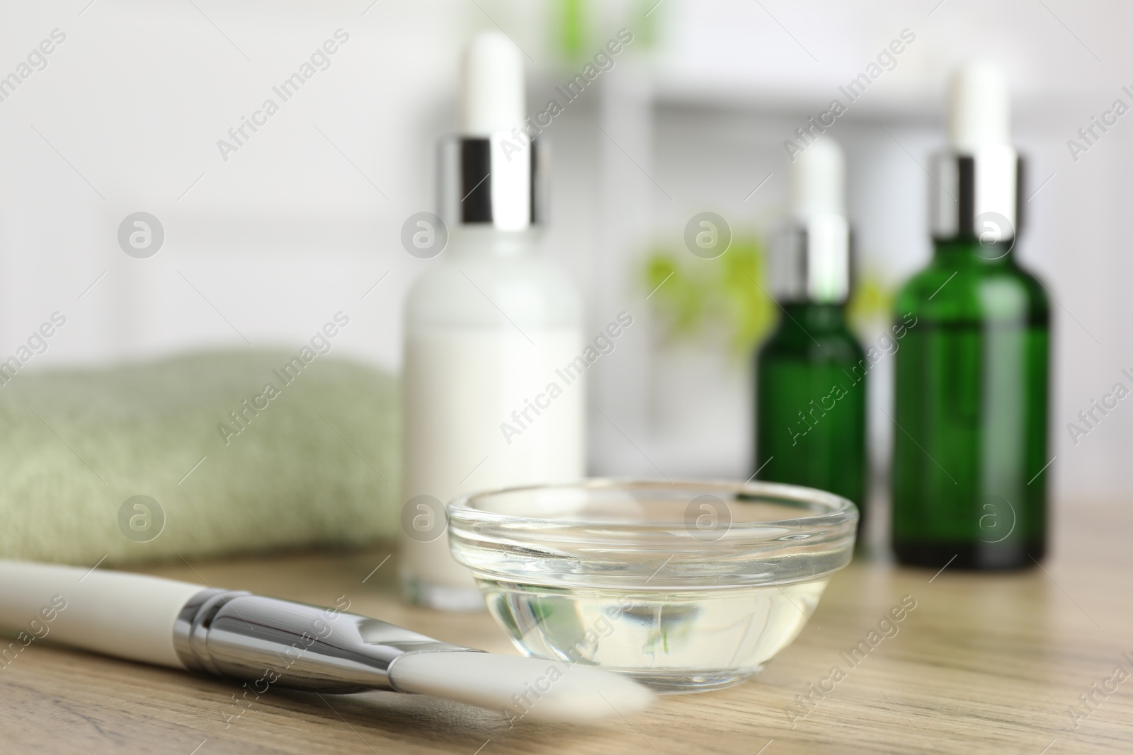 Photo of Peeling procedure. Bottles of chemical peel, bowl with liquid and brush on wooden table indoors