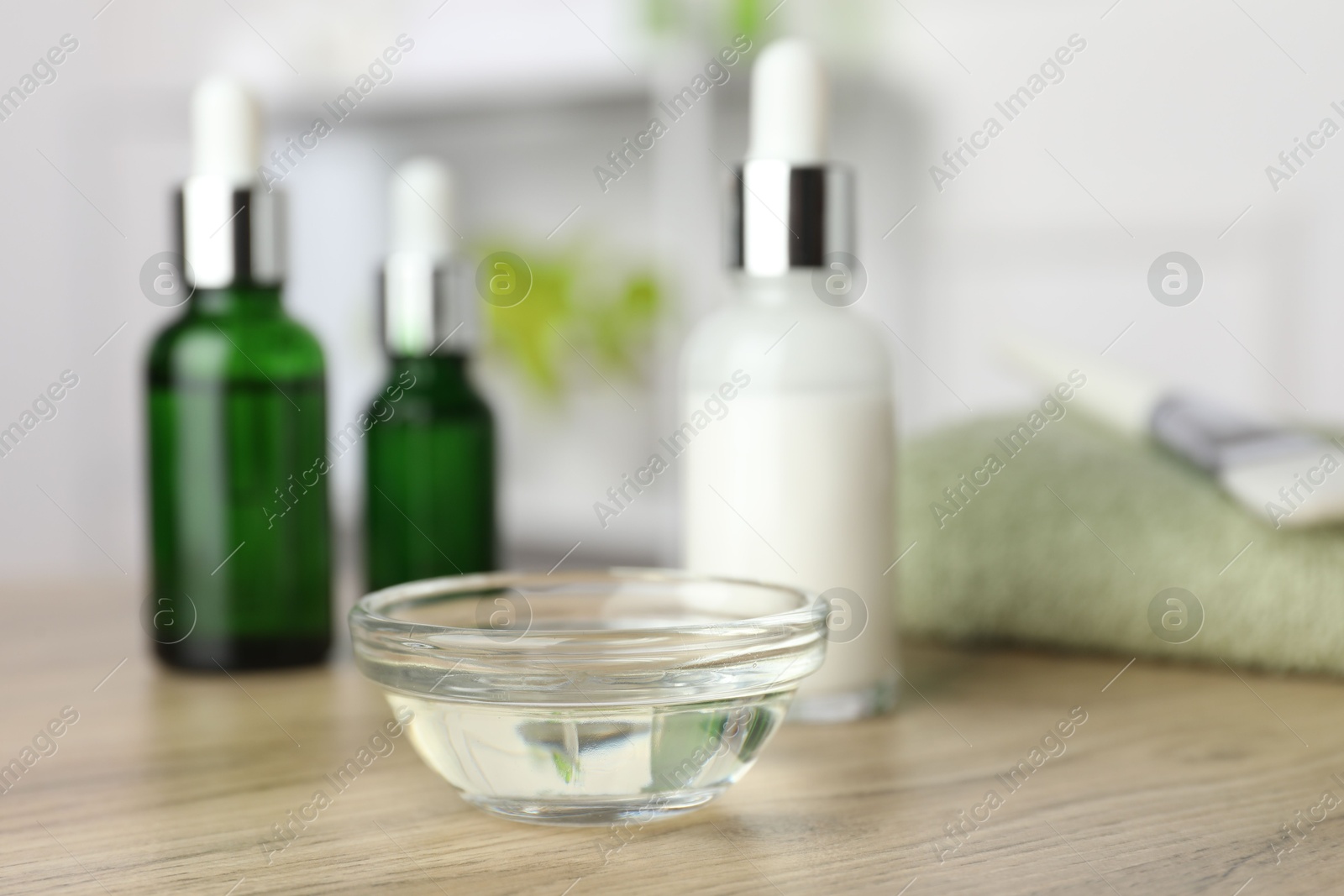 Photo of Peeling procedure. Bottles of chemical peel and bowl with liquid on wooden table indoors