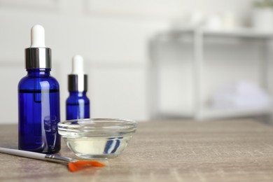 Peeling procedure. Bottles of chemical peel, bowl with liquid and brush on wooden table indoors. Space for text