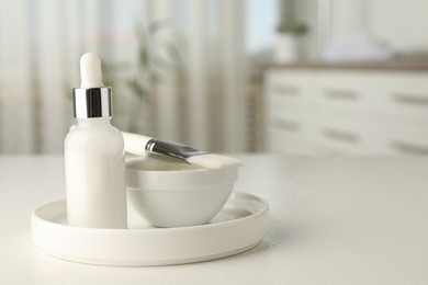 Peeling procedure. Bottle of chemical peel, bowl with liquid and brush on white table indoors. Space for text