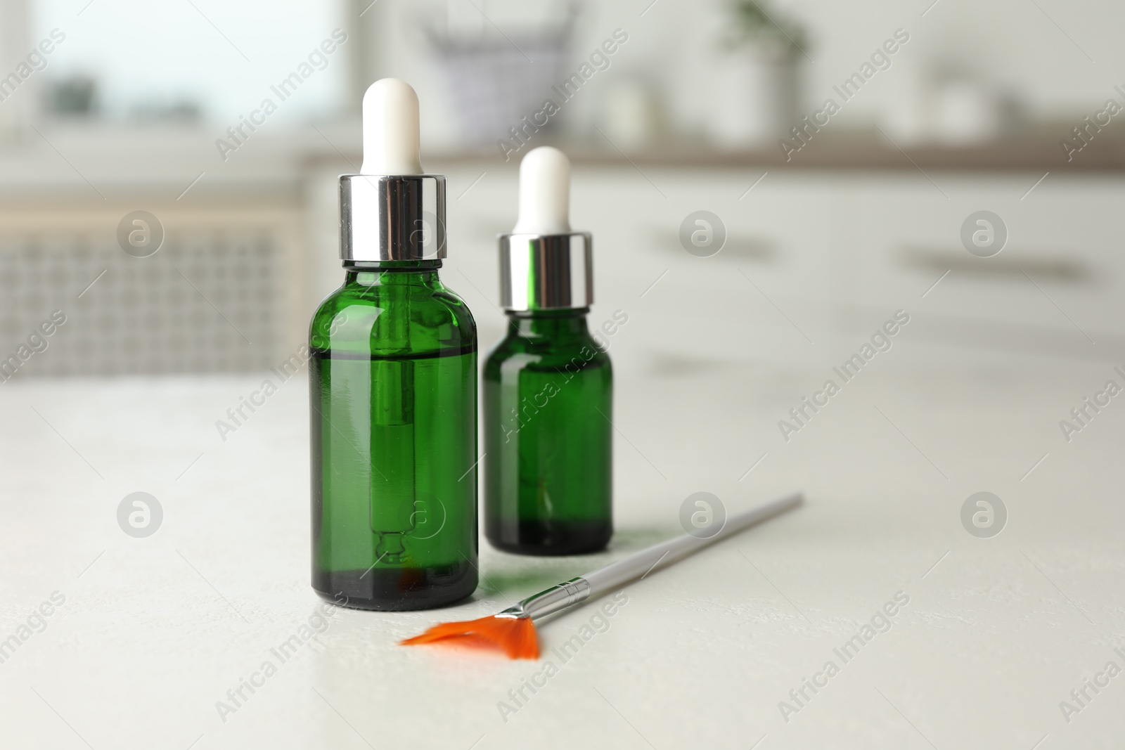 Photo of Peeling procedure. Bottles of chemical peel and brush on white table indoors