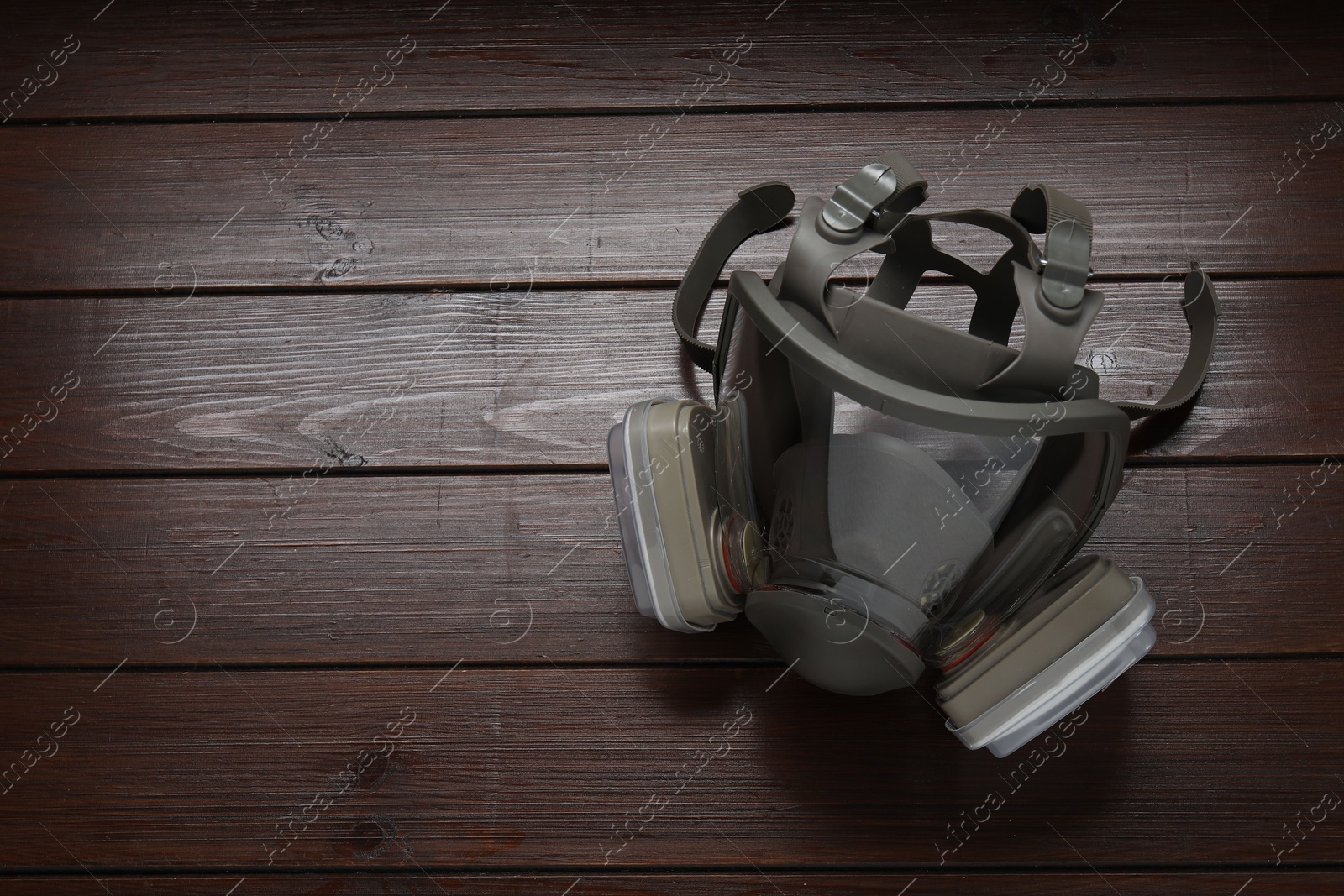 Photo of One respirator mask on wooden table, above view. Space for text