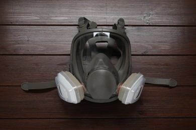 One respirator mask on wooden table, top view