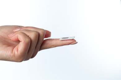 Woman with SIM card on white background, closeup