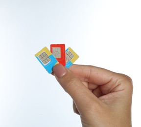 Woman with SIM cards on white background, closeup