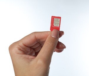 Woman with SIM card on white background, closeup