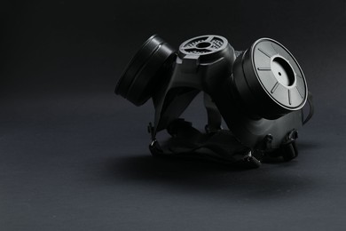 One gas mask on black background, space for text