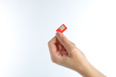 Woman with SIM card on white background, closeup