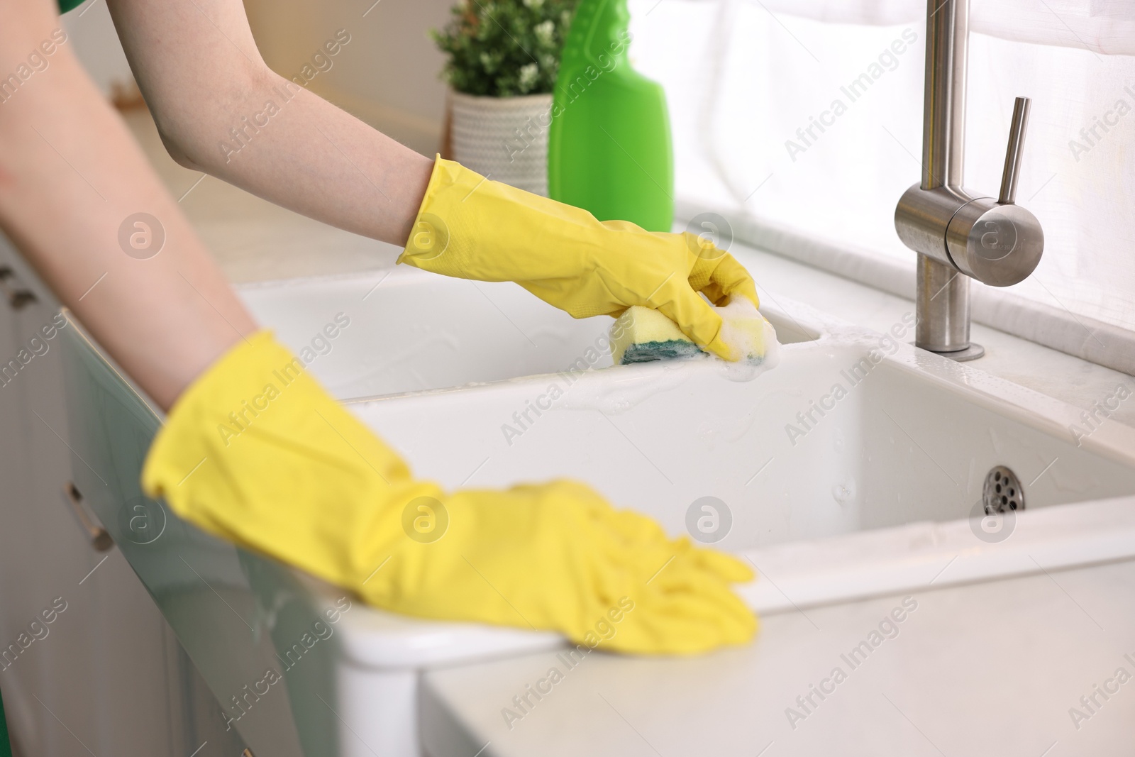 Photo of Professional janitor cleaning sink in kitchen, closeup