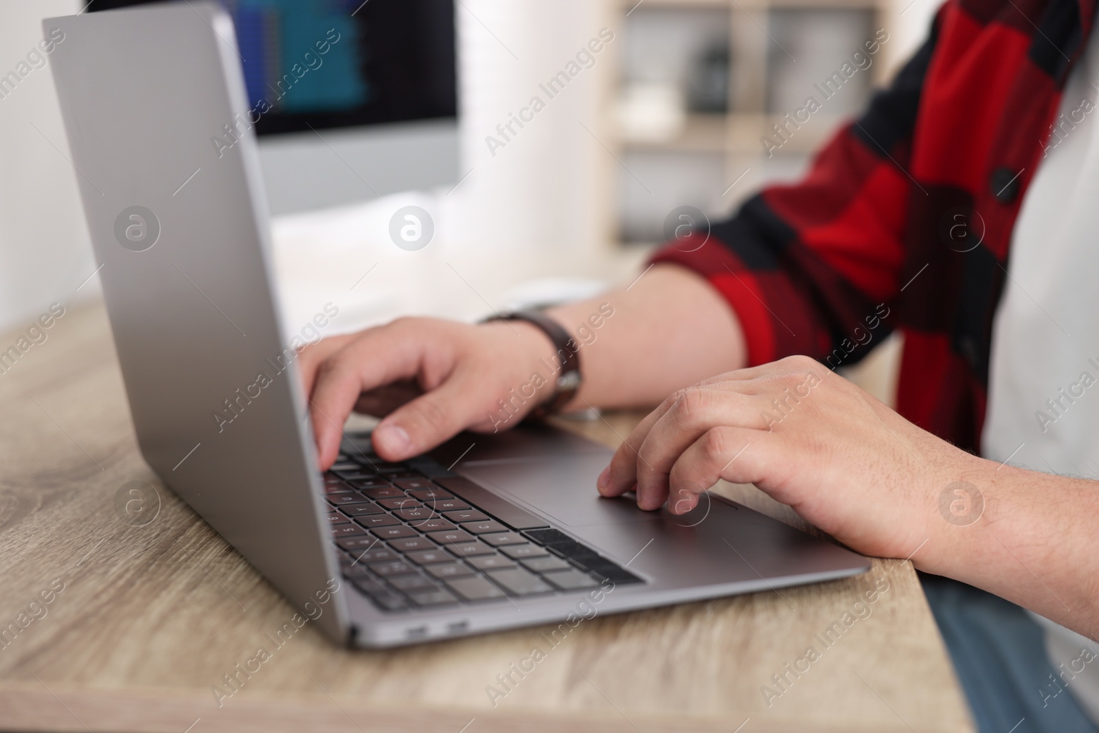 Photo of Programmer working with laptop at desk in office, closeup