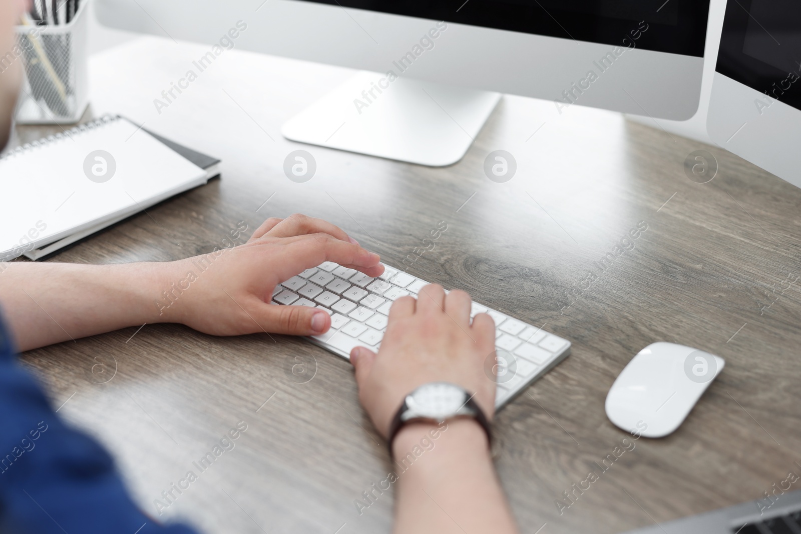 Photo of Programmer working with computer at desk in office, closeup