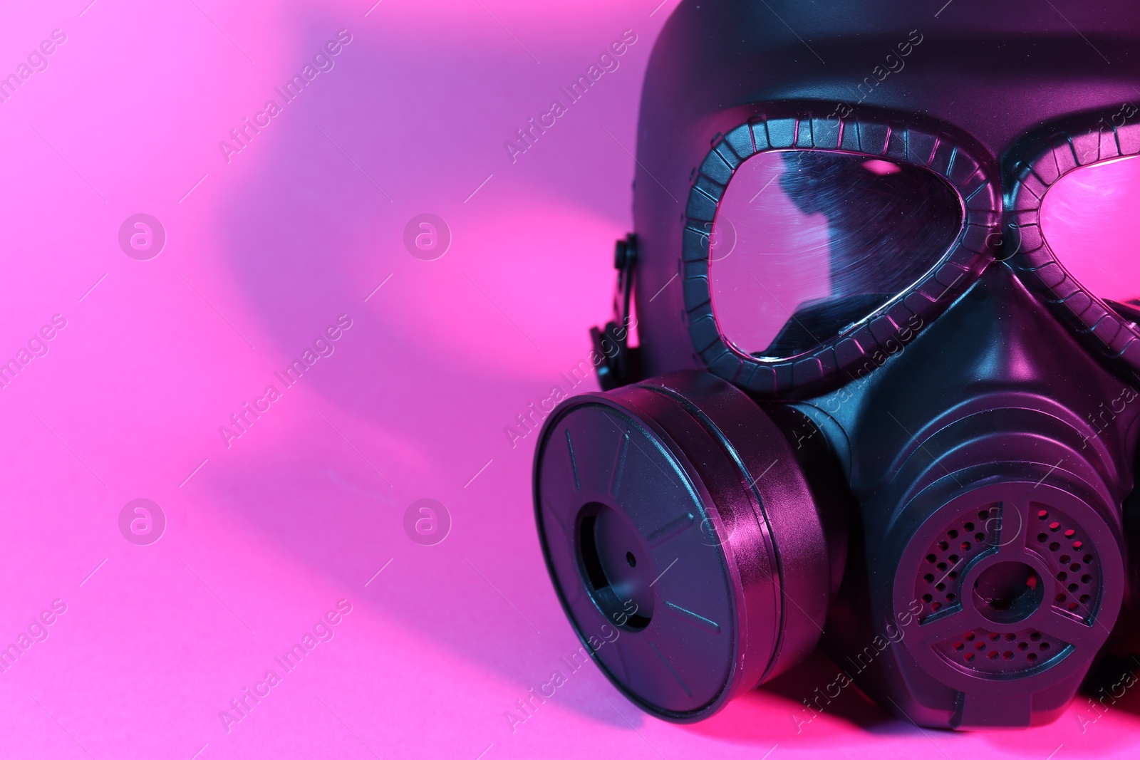 Photo of One gas mask on pink background, closeup. Space for text