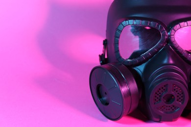 One gas mask on pink background, closeup. Space for text