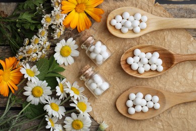 Photo of Homeopathic remedy. Flat lay composition with many pills, bottles and flowers on wooden table