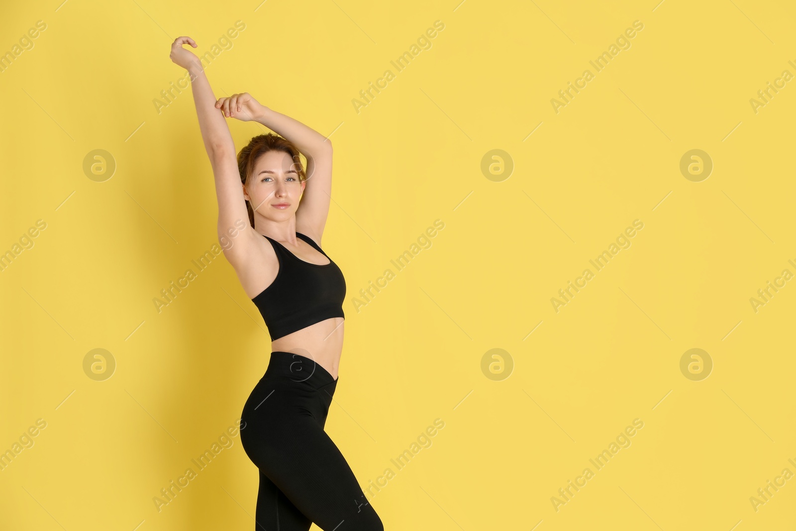 Photo of Woman with slim body posing on yellow background, space for text