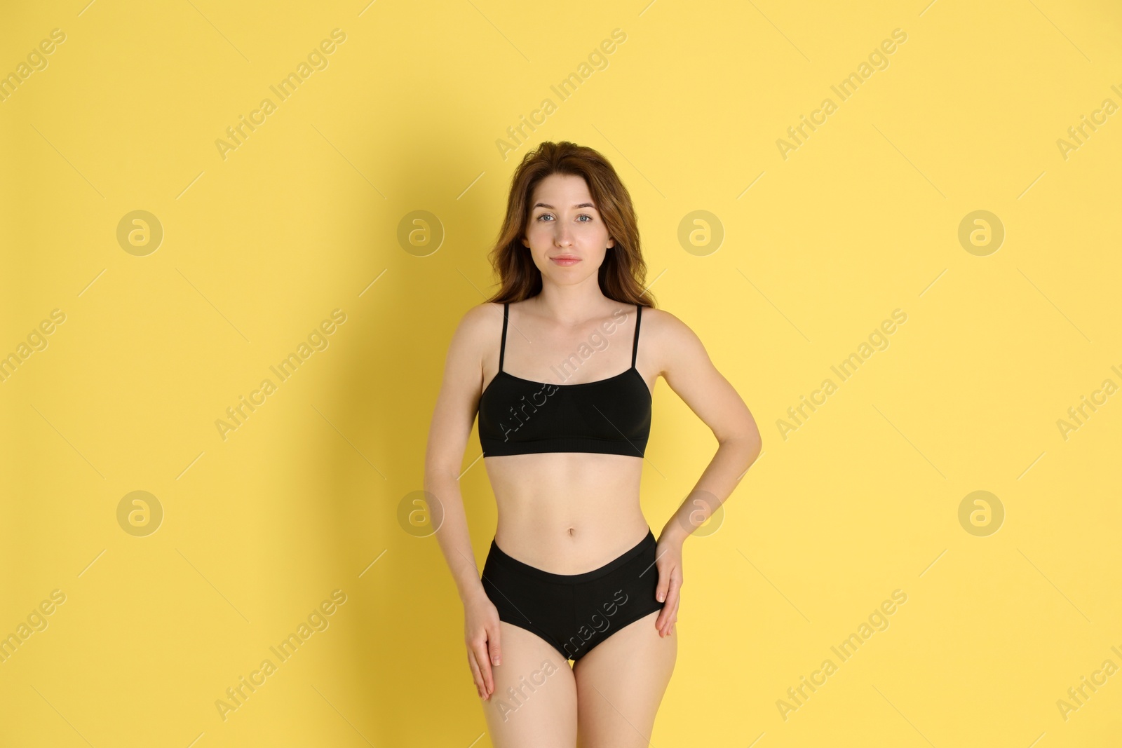 Photo of Woman with slim body posing on yellow background