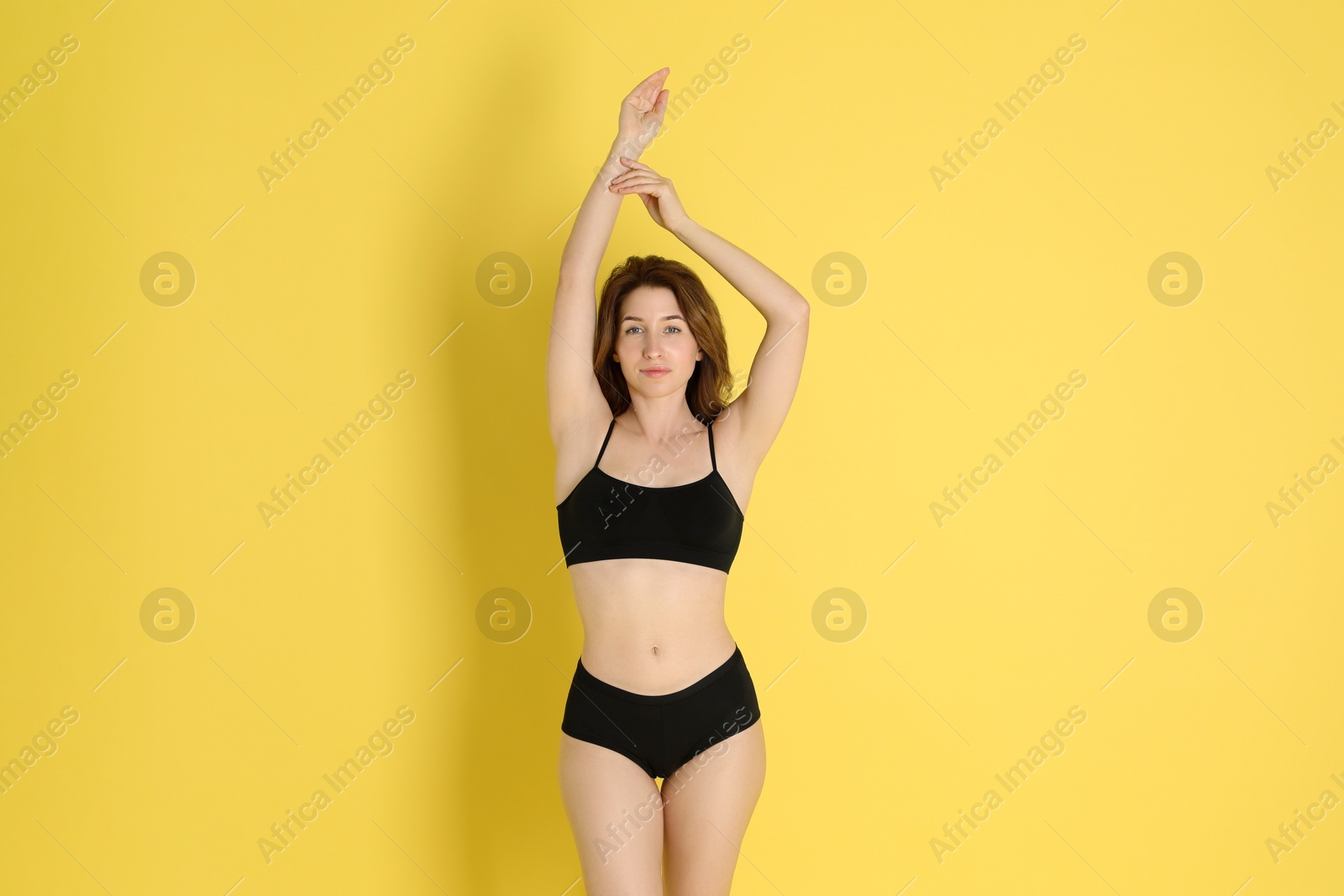 Photo of Woman with slim body posing on yellow background