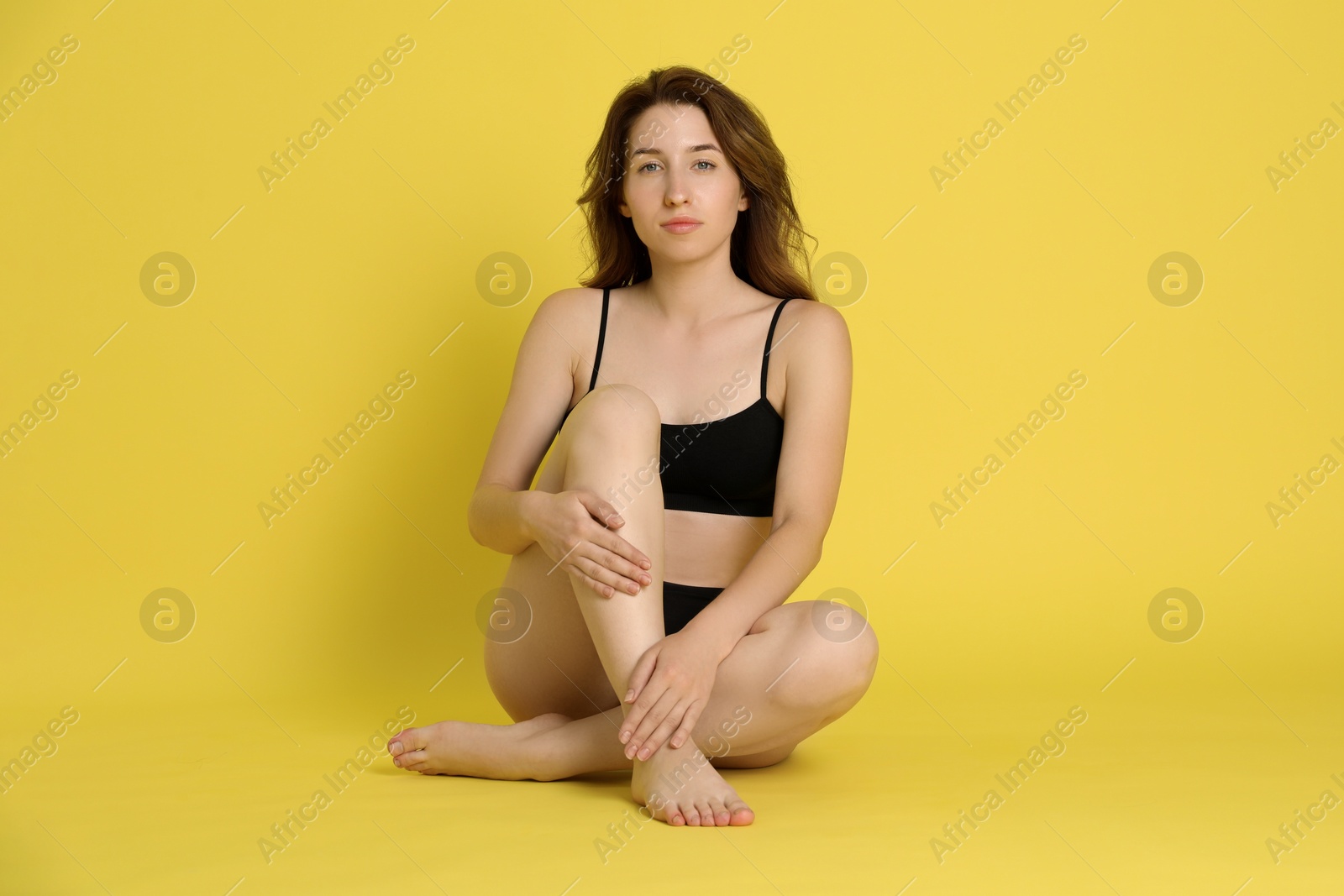 Photo of Woman with slim body posing on yellow background